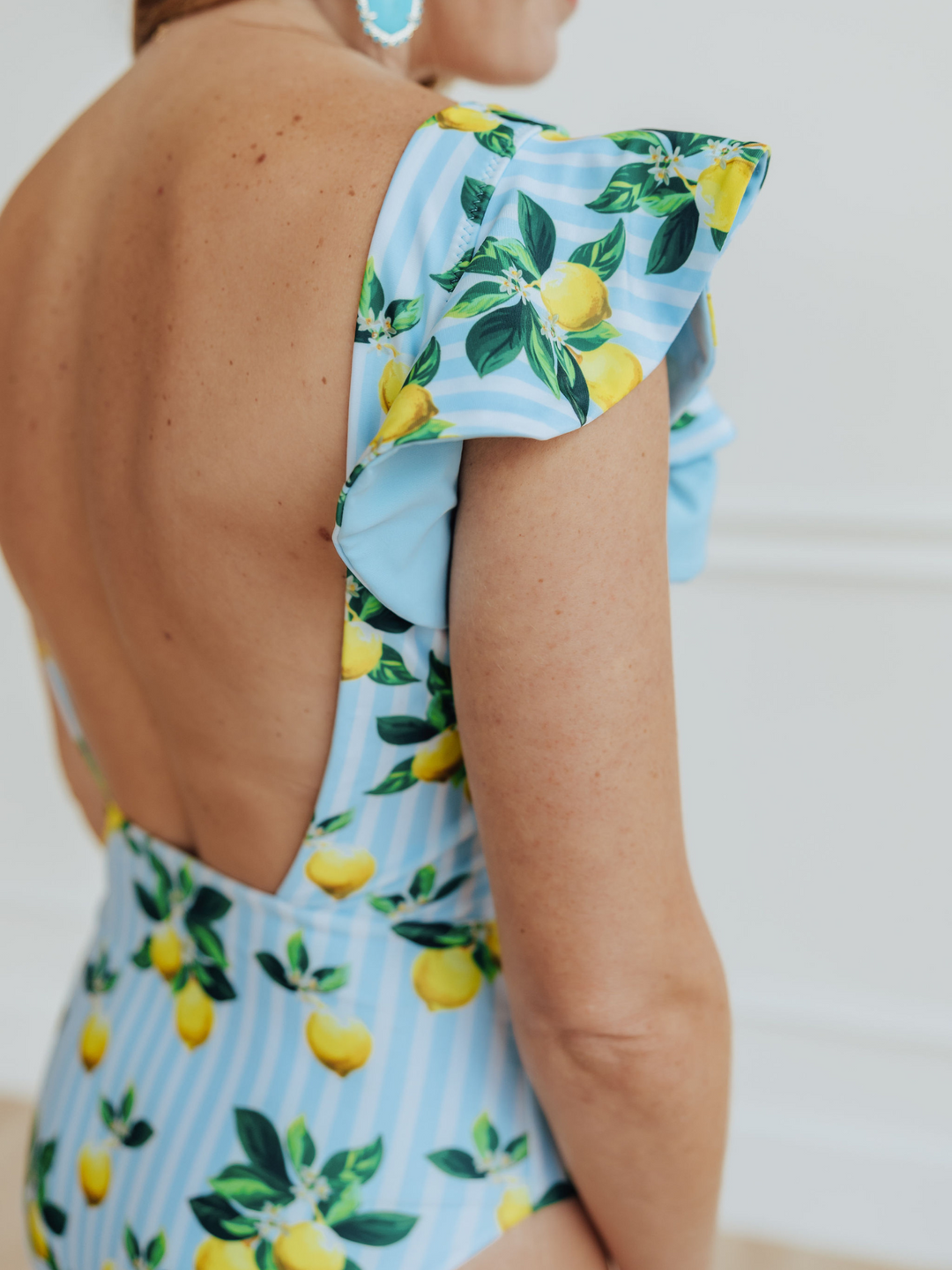 Women's Amalfi Coast Inspired Lemon One Piece Ruffle Swim Suit with Ruffle Sleeves and Square Back- women's Swimwear, Woman Standing in front of White Wall with Yellow Sandals, Close up Ruffle