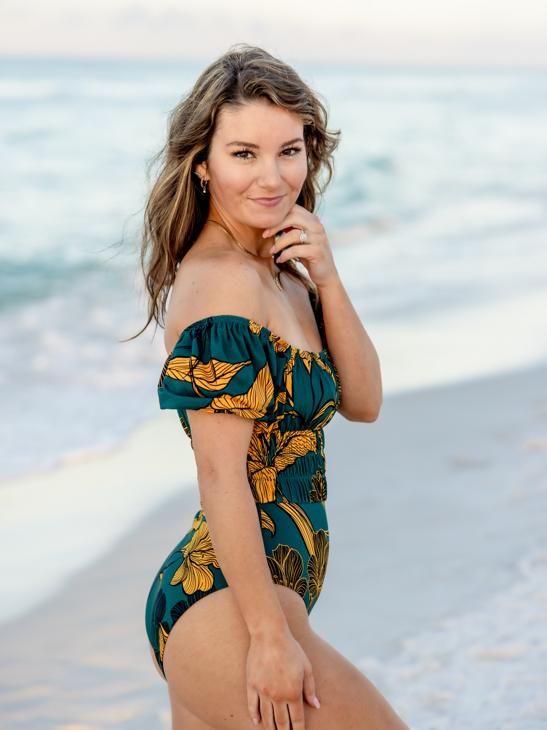 Women's Emerald Enchantment One Piece Swimsuit with Sleeves– women's swimwear, main image, Worn By Woman on the Beach, featuring a sleeves off of the shoulder.  Alternate Side View